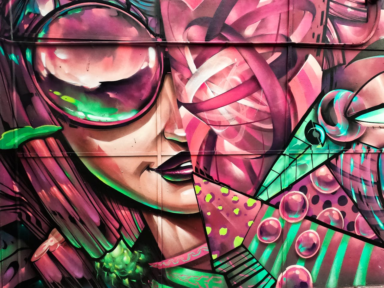 about-01 A vivid and colorful graffiti mural depicting abstract shapes and faces.