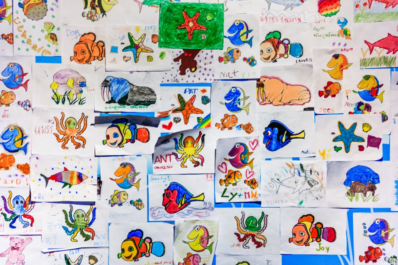 about-04 A colorful collage of children's drawings featuring various marine life in vibrant hues.